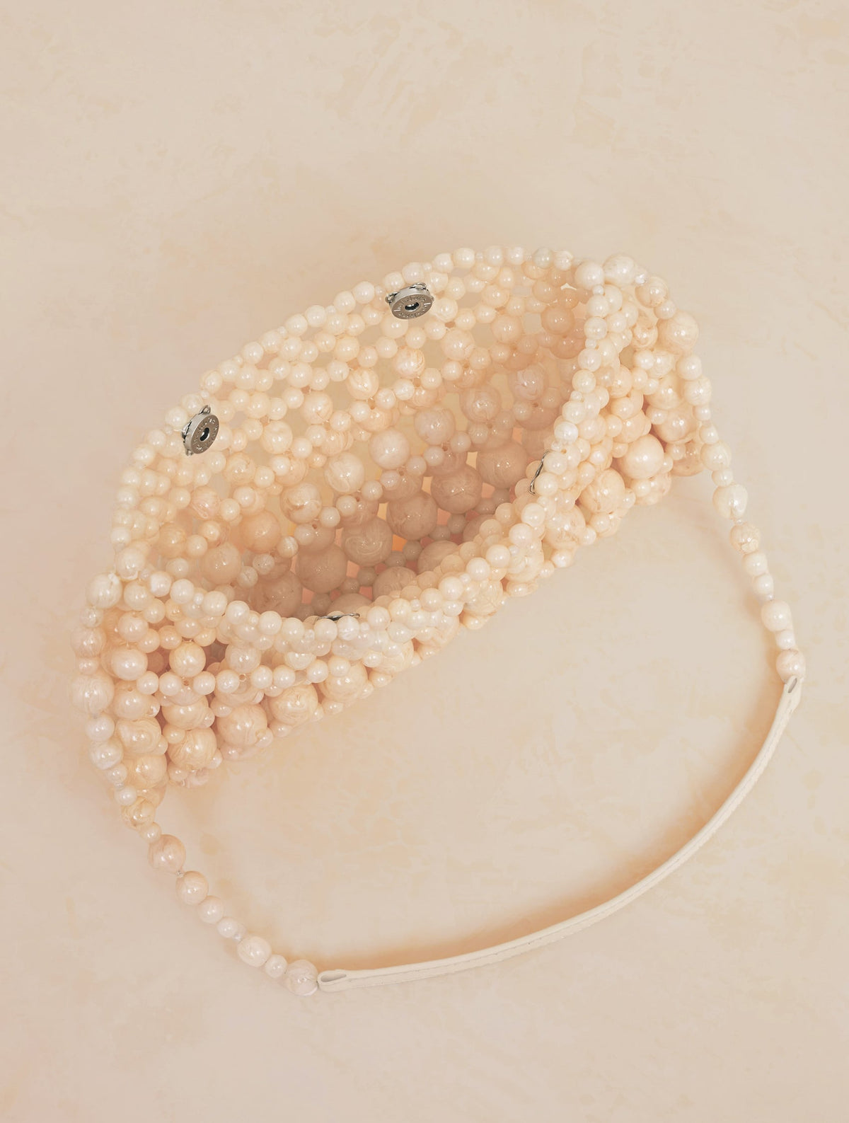 Bobbies Deià Ivory handbag — side product view on warm background